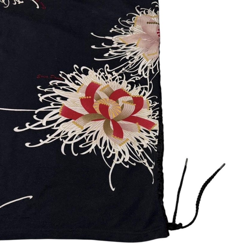 May include: Black drawstring bag with a floral pattern. The design features large, stylised flowers in red, white, and pink, with delicate white lines on a black background. The bag has black drawstrings.