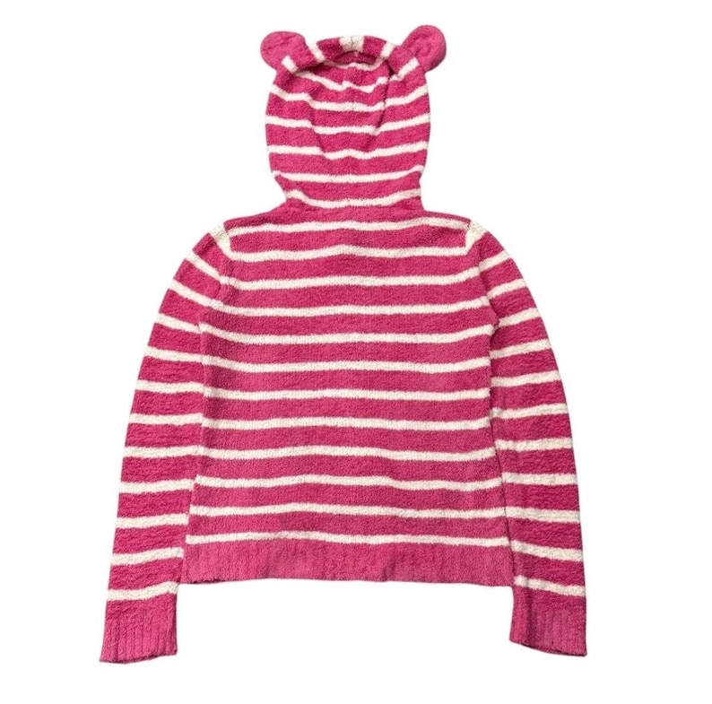 May include: Pink and white striped hooded sweater with bear ears on the hood. The sweater has long sleeves and a ribbed hem and cuffs. The horizontal stripes alternate between pink and white.