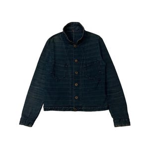 Könnte beinhalten: Dunkelblaue Jeansjacke mit Stehkragen und Knopfleiste. Die Jacke hat zwei Vordertaschen und ein strukturiertes Streifenmuster. Die Ärmel sind lang, und die Jacke ist vor weißem Hintergrund.