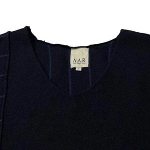 Puede incluir: Un su&eacute;ter de cuello en V azul marino con un dise&ntilde;o &uacute;nico. El su&eacute;ter presenta un panel en contraste en el lado izquierdo con rayas azules horizontales. La etiqueta dice "A.A.R."