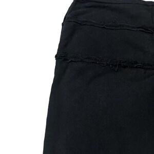 Puede incluir: Falda negra con un dise&ntilde;o en capas. La falda tiene un color liso y un aspecto texturizado. Las capas tienen un borde deshilachado.