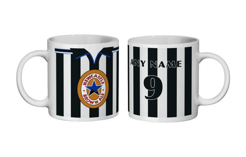 May include: Two white ceramic mugs with black and white stripes. One has the Newcastle Brown Ale logo, the other has "ANY NAME" and the number 9. A football-themed design.