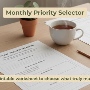 Può includere: Una scena di lavoro con un foglio di lavoro stampabile "Monthly Priority Selector", una tazza di tè, una matita e una piccola pianta in vaso. Il foglio di lavoro è progettato per aiutare gli utenti a scegliere ciò che conta davvero.