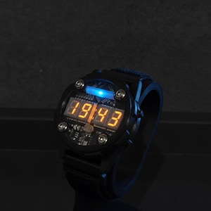 May include: Black digital watch with a blue backlight and orange digital display showing the time. The watch has a black strap and a round face with visible circuit board details. The time displayed is 89:43.