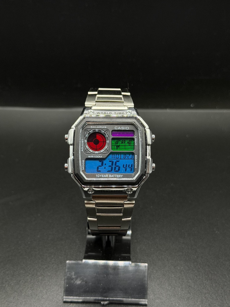 May include: A silver Casio digital watch with a stainless steel band. The watch face displays the time, date, and other functions. The watch has the text "WORLD TIME", "CASIO", and "10 YEAR BATTERY".