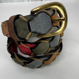 Könnte beinhalten: Geflochtener Ledergürtel mit einer Messingschnalle. Der Gürtel hat ein Patchwork-Design mit verschiedenen Farben, darunter Braun, Grau, Grün und Rot. Der Gürtel ist etwa 3,8 cm breit.