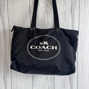 Bolso tote plegable de nailon negro con logo de Coach, con compartimento para cosméticos, ideal para el gimnasio, viajes o trabajo.