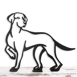 May include: A black metal silhouette of a dog in a standing pose. The dog is depicted with clean lines and a minimalist design, showcasing its form and features. The dog's tail is slightly curved, and the head is turned to the side.