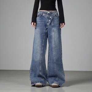 Women's Baggy Button Jeans | Irregular Stacked Pants | Streetwear Y2k Fashion

Wide-leg stacked denim pants with an irregular button fly, styled with a fitted long-sleeve top in a studio setting.