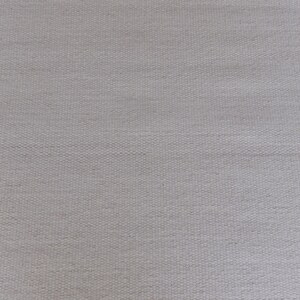 May include: A light gray fabric with a visible woven texture. The material features a consistent, tight grid pattern created by the interlacing of individual threads, resulting in a uniform, matte surface appearance across the entire frame.