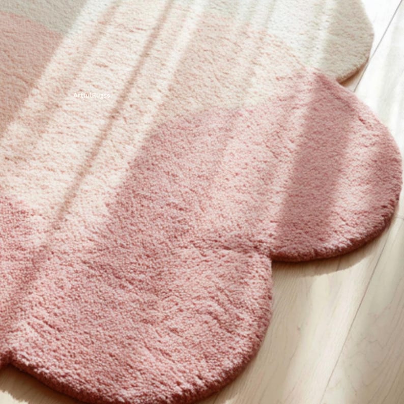Peut inclure: Tapis en forme de fleur dans des tons rose et cr&egrave;me. Le tapis pr&eacute;sente une surface textur&eacute;e et des bords arrondis. Le d&eacute;grad&eacute; de couleurs cr&eacute;e un effet ombr&eacute; subtil. Fabriqu&eacute; dans un mat&eacute;riau doux et absorbant, id&eacute;al pour une salle de bain.