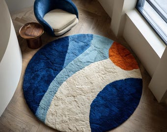 Peut inclure: Un tapis rond texturé présentant des blocs de couleurs abstraits et incurvés en bleu marine profond, bleu clair, crème et orange brûlé. Le tapis affiche le texte ArtfulRugs au centre, avec une construction en poils touffetés.