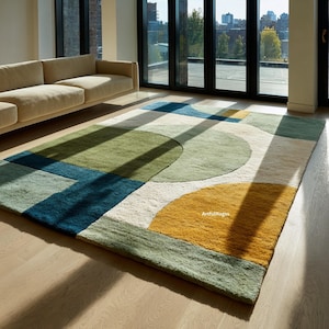 May include: A contemporary geometric rug with a colourful design. The rug incorporates shapes and colours such as green, blue, yellow, and white. The rug is rectangular and appears to be made of a soft, woven material. The text "Artful Rugs" is visible.