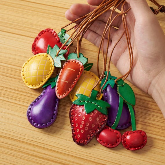 Handmade leather fruit charms (cherries, strawberries) that are weirdly charming and kawaii without being tacky — the kind of keychain that gets compliments.