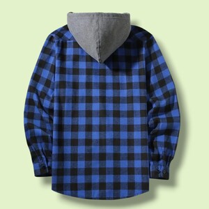 May include: A long-sleeved button-up shirt featuring a blue and black buffalo plaid pattern. The garment includes a solid grey hood attached at the collar, long sleeves with buttoned cuffs, and a straight hemline, shown from the back view.