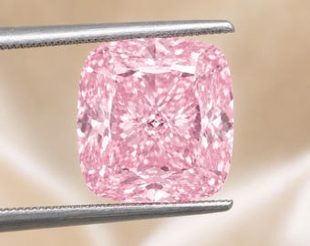 Op de afbeelding: Een kussengeslepen roze edelsteen met een gefacetteerd oppervlak dat licht reflecteert, vastgehouden door een zilverkleurige metalen pincet. De steen heeft een vierkante vorm met afgeronde hoeken en een levendige, egale lichtroze kleur.