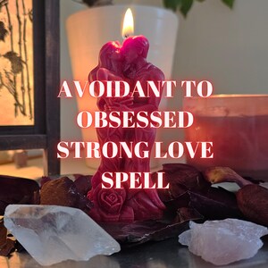 Może przedstawiać: Bordowa świeca w kształcie dwóch obejmujących się postaci, z płomieniem na górze. Świeca ma białe słowa "Avoidant to Obsessed Strong Love Spell". Kryształy i suszone płatki otaczają świecę.