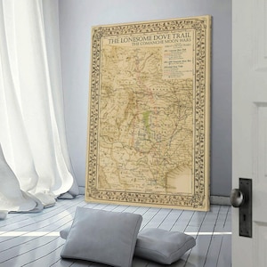 Puede incluir: Una impresi&oacute;n de mapa vintage titulada "The Lonesome Dove Trail The Comanche Moon Wars Great Cattle Trails". El mapa presenta una ilustraci&oacute;n detallada de un sendero hist&oacute;rico, con bordes florales decorativos. El mapa se muestra en una habitaci&oacute;n con cortinas y almohadas blancas.