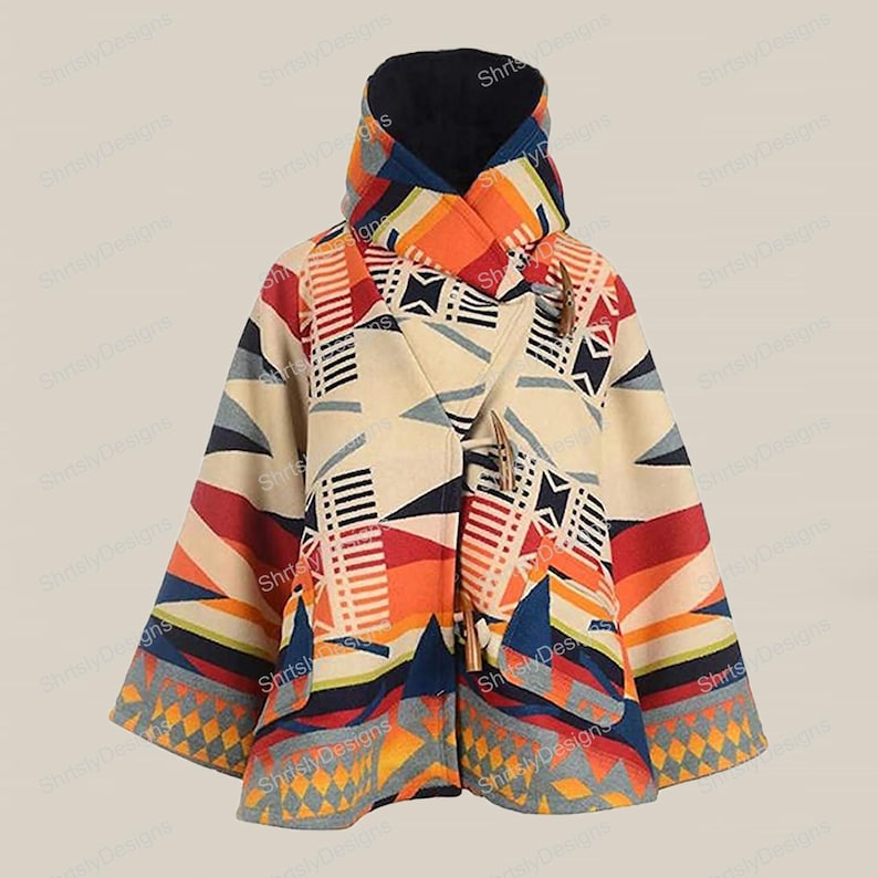 May include: A hooded poncho-style coat with a geometric pattern in cream, orange, red, blue, and gray. The coat features a toggle closure and a black-lined hood. The design includes triangles, stripes, and diamond shapes.
