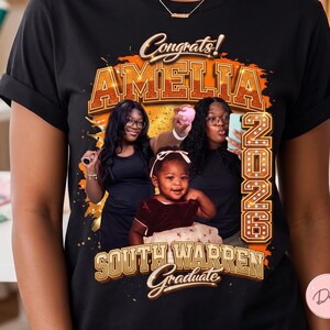 Pode incluir: Camiseta preta com um design de formatura. O design inclui o texto "Congrats! AMELIA 2023 SOUTH WARREN Graduate" com uma foto de três pessoas. O texto e a foto são em tons de laranja e dourado.