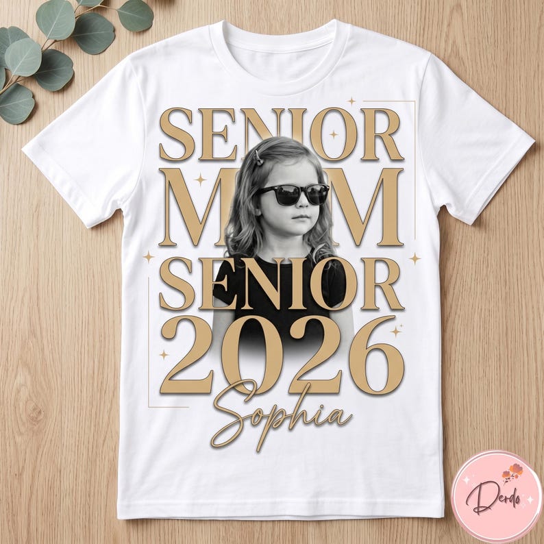 May include: White t-shirt featuring a black and white photo of a young girl wearing sunglasses. The shirt has the words "SENIOR MOM SENIOR 2026 Sophia" in gold lettering, with star accents. A personalized graduation gift.