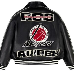 Peut inclure: Une veste universitaire en cuir noir avec des passepoils blancs et des poignets c&ocirc;tel&eacute;s &agrave; rayures blanches. Le dos pr&eacute;sente de grands &eacute;cussons avec le texte "FOG", "AVIREX BASKETBALL SPORTS", "NEW YORK" et "AVIREX" ainsi qu'un motif de ballon de basket.