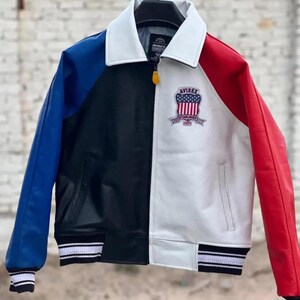 May include: A white ceramic mug with a black handle and the text "But First, Coffee" in a bold, black font. The mug is set against a blurred background, suggesting a cozy setting.