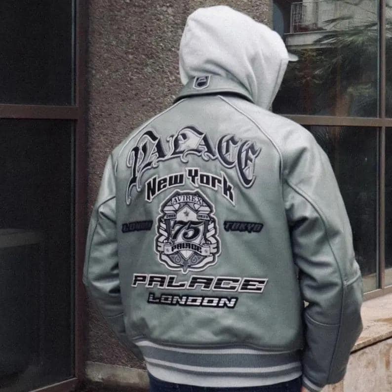 May include: A light green leather jacket with the word "PALACE" in large, stylized lettering across the back. Below the word "PALACE" are the words "New York", "London", and "Tokyo". The jacket has a white hood.