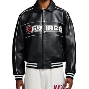 Peut inclure: Une veste universitaire en cuir noir avec un passepoil blanc le long des manches et de la poitrine. L'avant pr&eacute;sente un graphique de ballon de basket rouge et le texte AVIREX en lettres blanches. Elle poss&egrave;de des boutons, un col et des poignets ray&eacute;s.