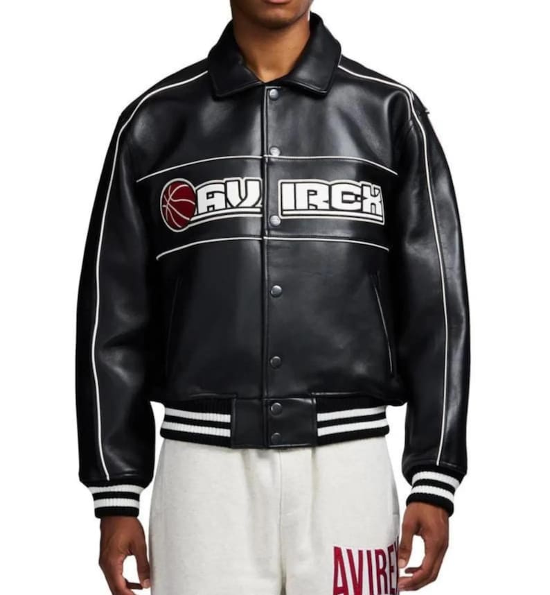 Peut inclure: Une veste universitaire en cuir noir avec un passepoil blanc le long des manches et de la poitrine. L'avant pr&eacute;sente un graphique de ballon de basket rouge et le texte AVIREX en lettres blanches. Elle poss&egrave;de des boutons, un col et des poignets ray&eacute;s.