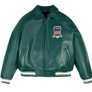 Może przedstawiać: Zielona sk&oacute;rzana kurtka z zapięciem na zamek błyskawiczny, kołnierzem i naszywką na piersi. Kurtka ma biało-czarne paski na mankietach i w pasie. Naszywka przedstawia wz&oacute;r tarczy z czerwono-białymi paskami i napisem "AVIREX".