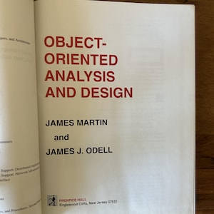 May include: The title page of the book Object-Oriented Analysis and Design by James Martin and James J. Odell. The text is printed in red and black ink on a white page, featuring the Prentice Hall logo and location in Englewood Cliffs, New Jersey.