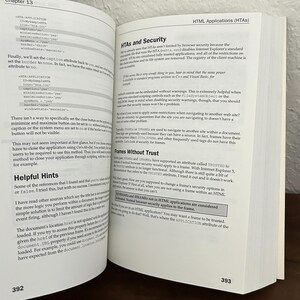May include: An open technical book showing pages 392 and 393. The left page features code snippets for HTA applications, while the right page contains text under the heading HTML Applications (HTAs) and a section titled HTAs and Security.
