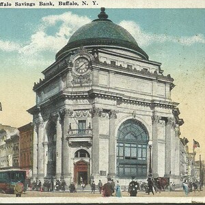 May include: Vintage postcard of the Buffalo Savings Bank in Buffalo, NY. The building is a large, ornate structure with a domed roof and a clock. The image includes street scenes with people, trolleys, and American flags.