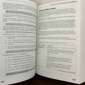 May include: An open technical textbook showing pages 214 and 215. The left page is titled Chapter 7 and discusses Dictionary object methods and properties. The right page covers the FileSystemObject object with a table of objects and descriptions.