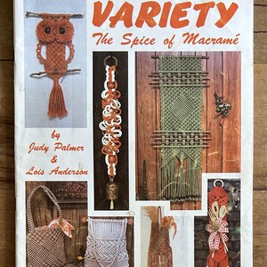 May include: A craft instruction booklet titled Variety The Spice of Macramé by Judy Palmer and Lois Anderson. The cover features photographs of various macramé projects including an owl, a bell hanger, wall hangings, bags, and kitchen decor.
