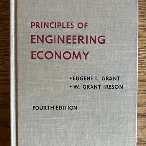 May include: A hardcover book titled Principles of Engineering Economy, Fourth Edition, by Eugene L. Grant and W. Grant Ireson. The book features a light gray, textured fabric cover with the title printed in dark red and author names in black.