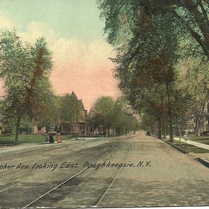 May include: Vintage postcard depicting Hooker Ave. in Poughkeepsie, NY, looking east. The image shows a tree-lined street with houses and a trolley track. The sky is a soft pink and blue. Text on the postcard reads "Hooker Ave. looking East, Poughkeepsie, N.Y."