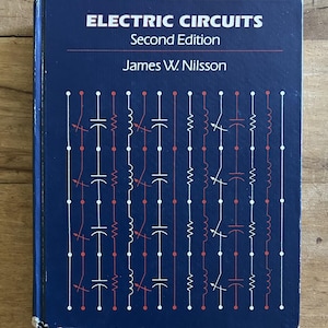 May include: A dark blue hardcover textbook titled Electric Circuits Second Edition by James W. Nilsson. The cover features a repeating pattern of white and red electrical circuit symbols, including resistors, capacitors, and inductors.
