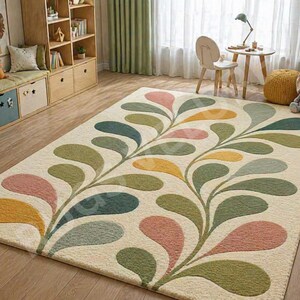 May include: A beige area rug with a colorful floral design. The rug features a repeating pattern of stylized leaves in shades of pink, green, yellow, and blue. The rug is rectangular and appears to be made of a soft material.