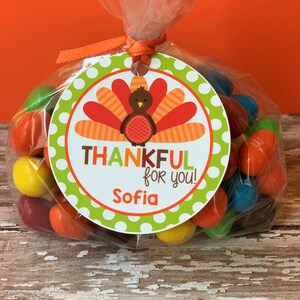Op de afbeelding: Een ronde groene en witte tag met een Thanksgiving-kalkoenontwerp. De tag zegt "Thankful for you!" en "Sofia".