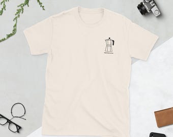 以下が含まれることがあります： クリーム色のTシャツ。黒い線で描かれたエスプレッソメーカーのイラストが特徴です。「Espressoing my love」の文字が下にプリントされています。カジュアルな服装です。