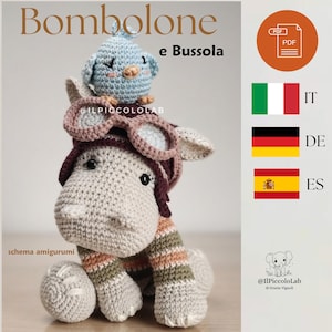 Puede incluir: Un hipopótamo amigurumi de ganchillo con un gorro de aviador marrón oscuro y gafas, con un pequeño pájaro azul claro sobre la cabeza. El hipopótamo tiene patas a rayas en tonos apagados. Texto Bombolone e Bussola y schema amigurumi.