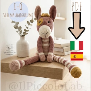 May include: A crocheted donkey amigurumi in pink, cream, and yellow, with long striped legs. The donkey is sitting on a wooden surface. The image includes text that says "I-O SCHEMA AMIGURUMI" and "PDF".