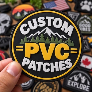 Może przedstawiać: Okrągła czarna naszywka z PVC z białym napisem CUSTOM u góry i PATCHES u dołu. W centrum znajduje się żółty napis PVC otoczony dwiema żółtymi poziomymi kreskami, z zielonym lasem i białymi górami w tle.