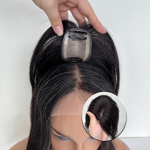 Könnte beinhalten: Ein schwarzes Haarteil mit Clip-Befestigung. Das Haarteil wird auf einem Schaufensterkopf mit dunklem Haar gezeigt. Eine Nahaufnahme zeigt die Basis und die Clips des Haarteils. Das Haarteil soll Volumen und Deckkraft verleihen.