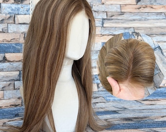 May include: A long, straight wig featuring light brown hair with subtle blonde highlights. The wig is displayed on a white mannequin head, showcasing a natural-looking part and a lace front construction visible in the circular inset detail.