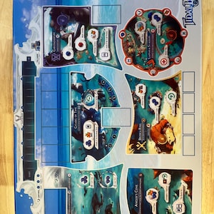 May include: A Tidal Blades Heroes of the Reef board game playmat featuring a blue ocean-themed surface with various game zones including Lamara Stadium, Citadel of Time, Droska Ring, and Angler's Cove, decorated with colorful illustrations and text.