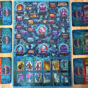 May include: A board game titled "Tyrants of the Underdark" with a blue and purple map design. The game includes cards with fantasy art and player boards. The game is set on a wooden surface.