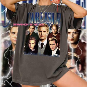 May include: Dark gray t-shirt featuring a collage of images and the text "CARLISLE Cullen" in a blue and white design. The shirt has a vintage, distressed look, with a faded graphic.